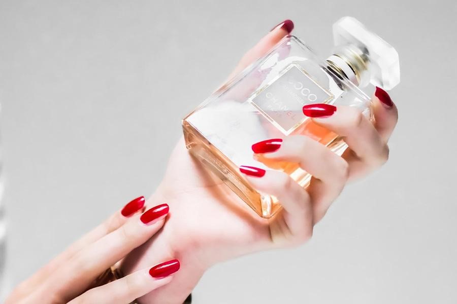 Woman’s hand holding a fragrance bottle