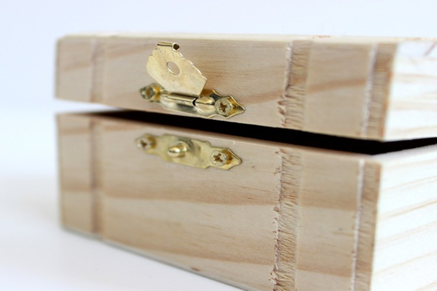 A wooden gift box with buckles to secure content