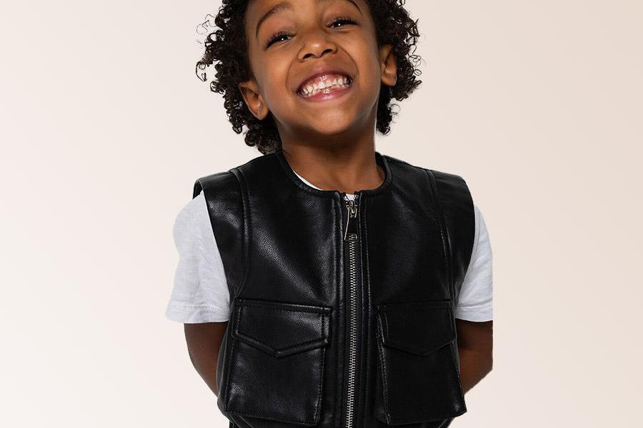 Young boy wearing a black leather utility vest