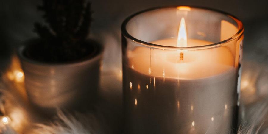 A candle sits on a bed of fur and lights