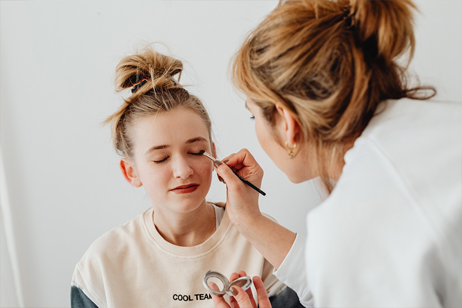 A makeup artist applying cosmetics to a woman