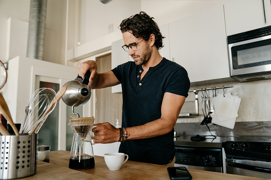 A man using pour-over glass beaker for coffee making 
