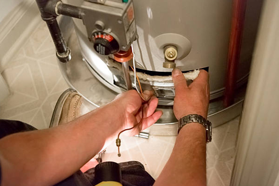 A man's hand fixing a boiler machine 