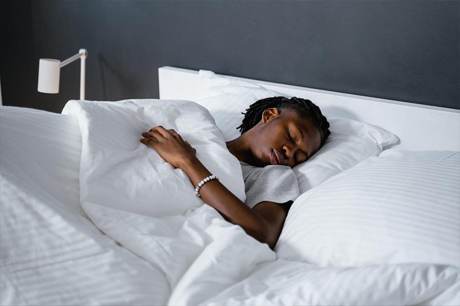 A person sleeping in soft white duvet