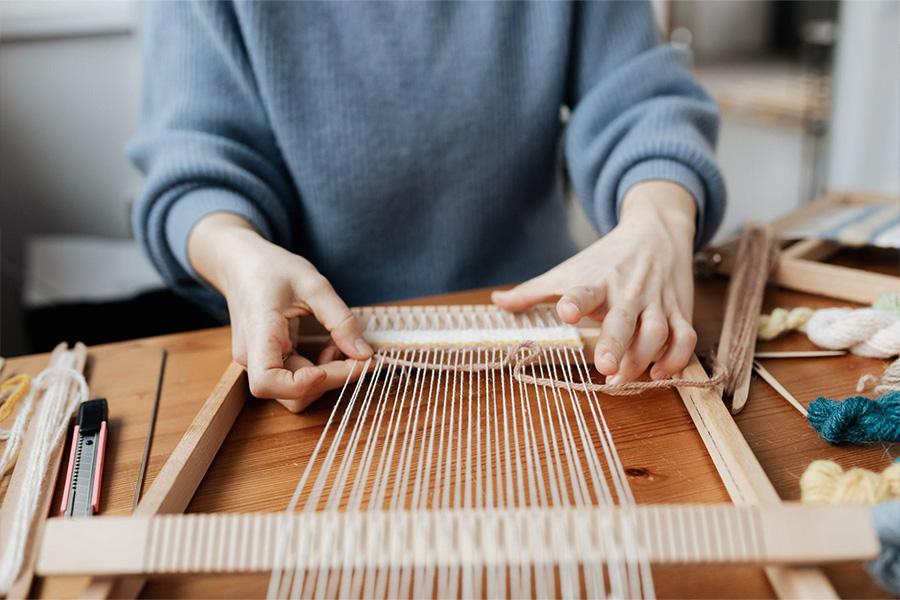 a woman making a hand loom
