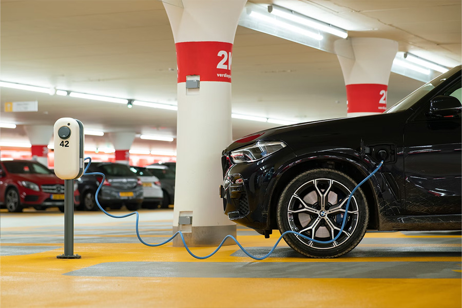 Black electric car charging inside an underground garage