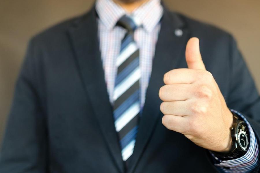 Business owner giving a thumbs-up and feeling positive about his company’s profitability