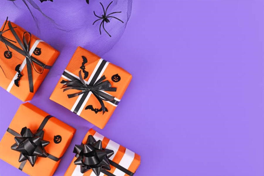 Halloween themed boxes wrapped in orange paper with black bows