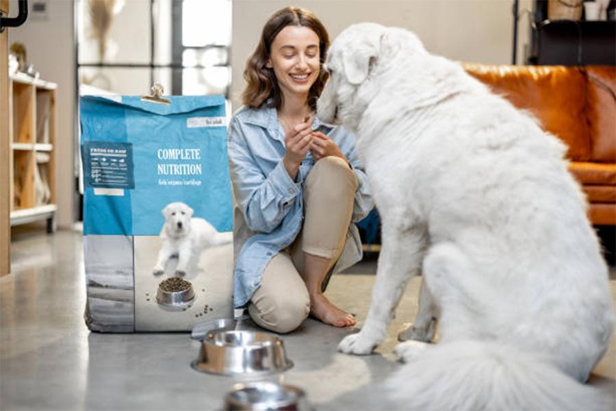 Large bag of dog food next to owner and dog