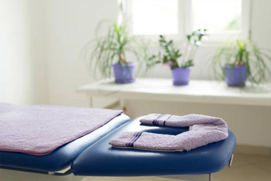 Lightweight navy blue massage table with purple towels on top