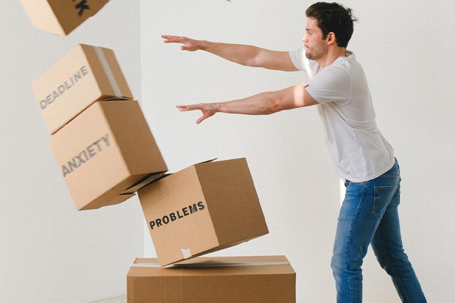 Man pushing over boxes with work and stress written on