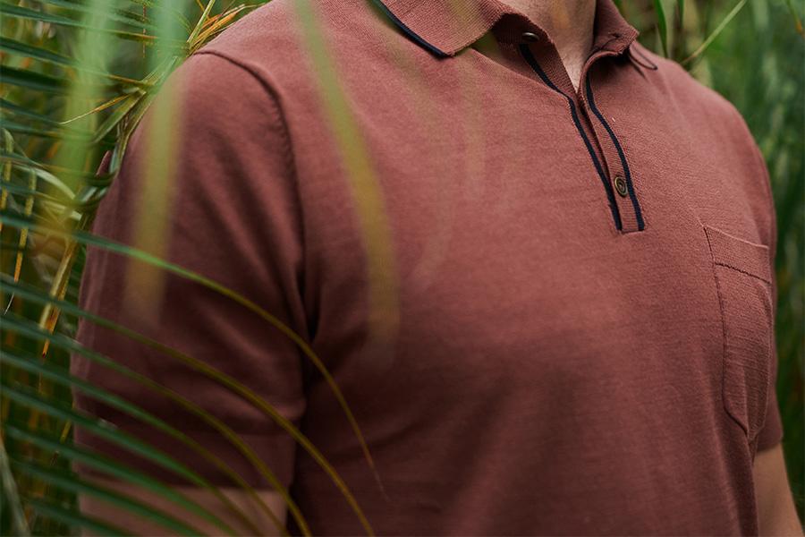 Man standing near leaves with red polo shirt