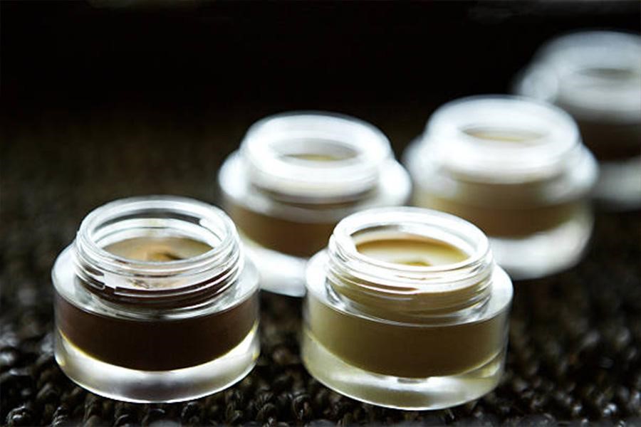 Mini glass jars being used to hold creams for face