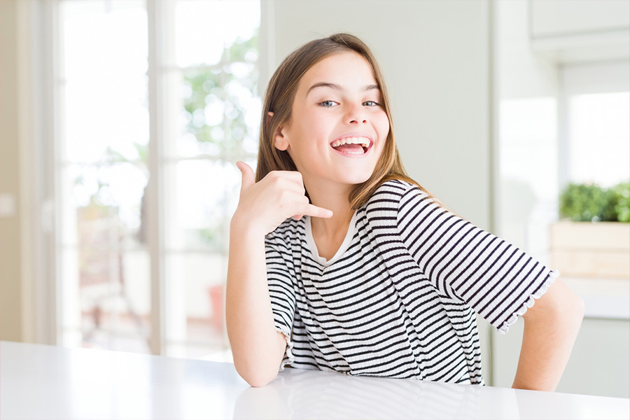 Smiling young girl wearing a drop-shoulder T-shirt