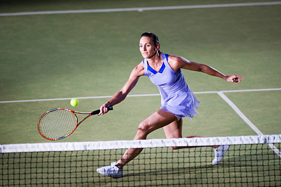 Woman in a purple tennis dress on the court