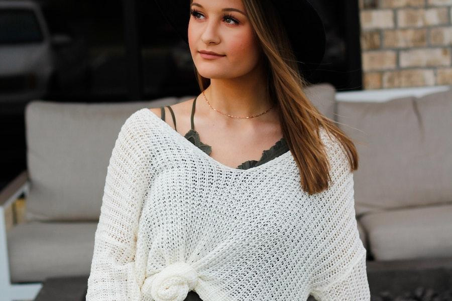 Woman looking up with a white knitted top