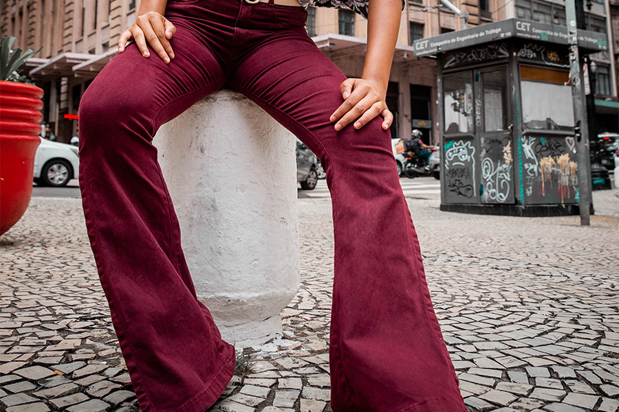 Woman posing on the street with red flared jeans