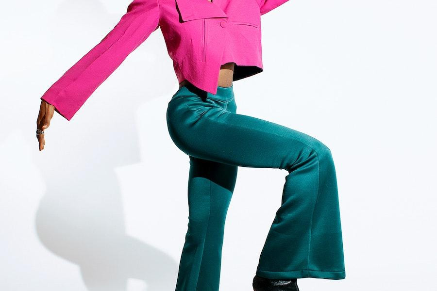 Woman posing with teal green flared trousers