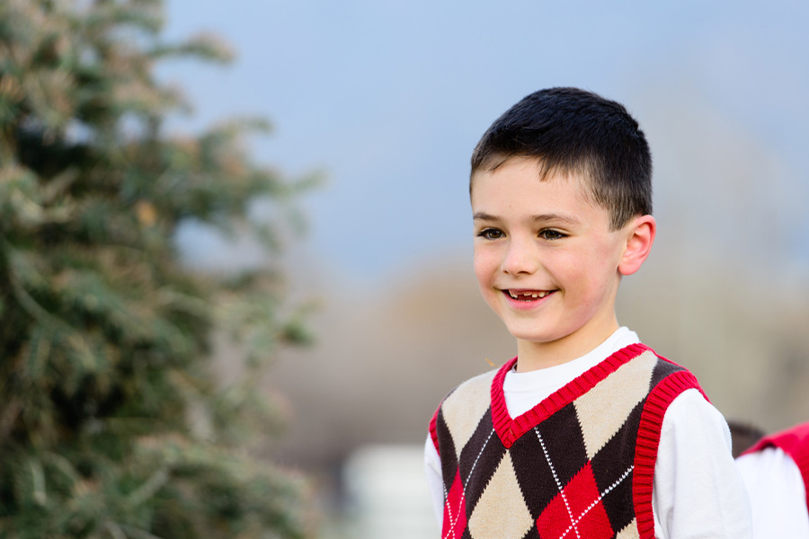 Young boy wearing sweater vest with argyle check pattern