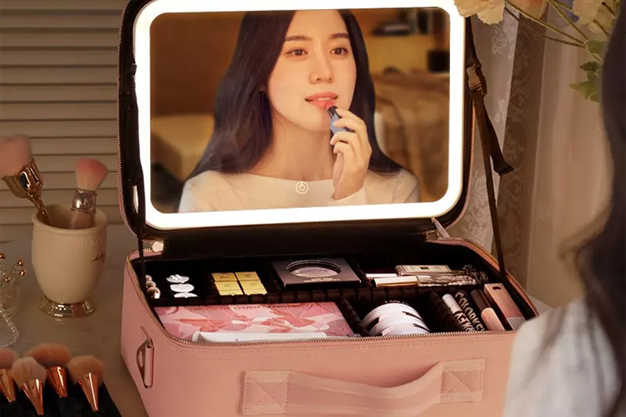 A lady using a pink travel makeup organizer