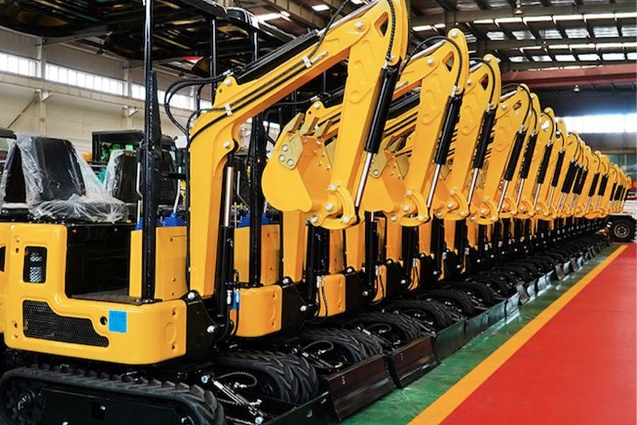A row of mini excavators lined up through a factory