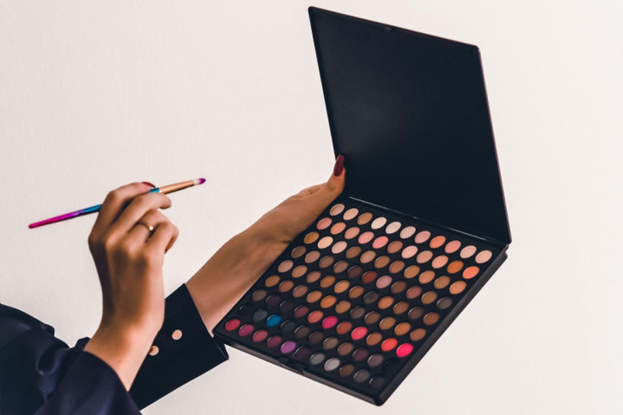 A woman holding an eyeshadow palette