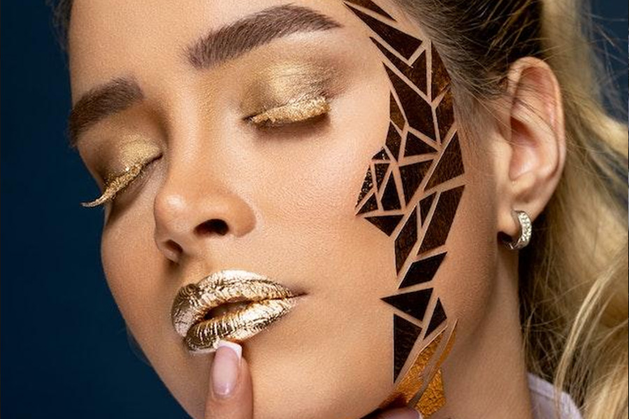 A woman wearing gold makeup