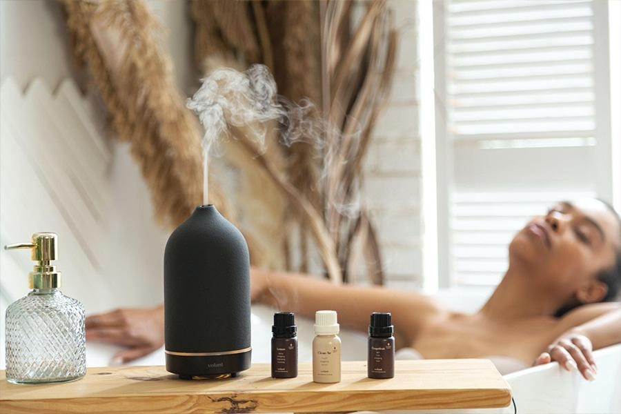 An aroma diffuser placed next to essential oils
