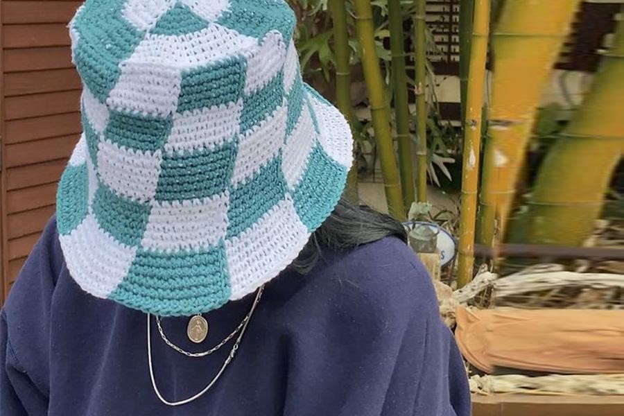 Blue and white checkered bucket hat covering a woman’s face