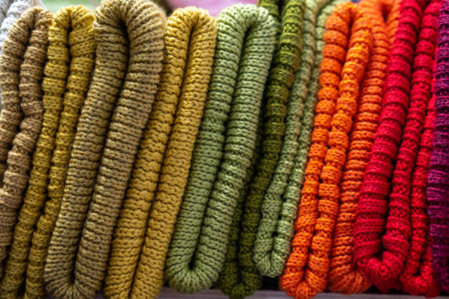 Different colors of knitted beanies lined up in a row