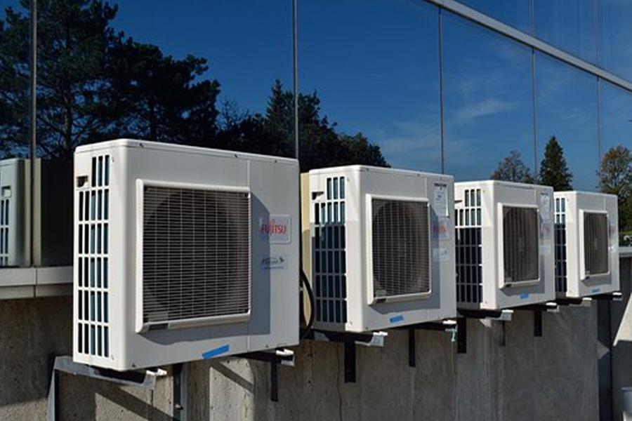 Four white air conditioner inverters fixed on a building