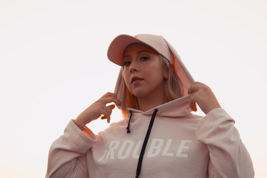Lady rocking a pink trucker hat in a pink hoodie