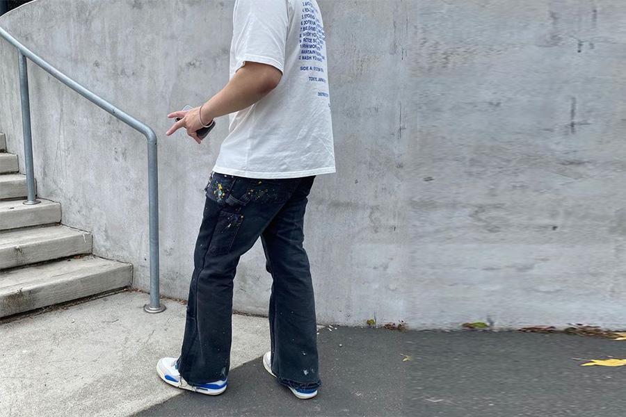 Man facing stairs in denim flared trousers