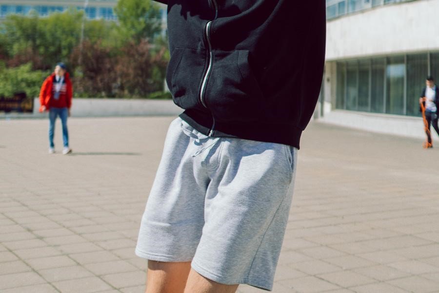 Man posing in gray shorts