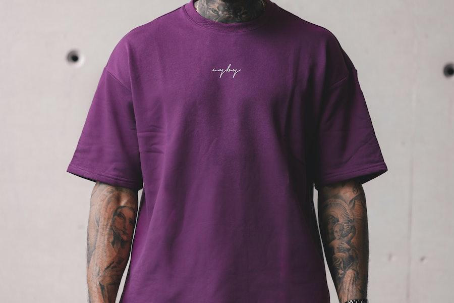 man standing in a purple oversized shirt