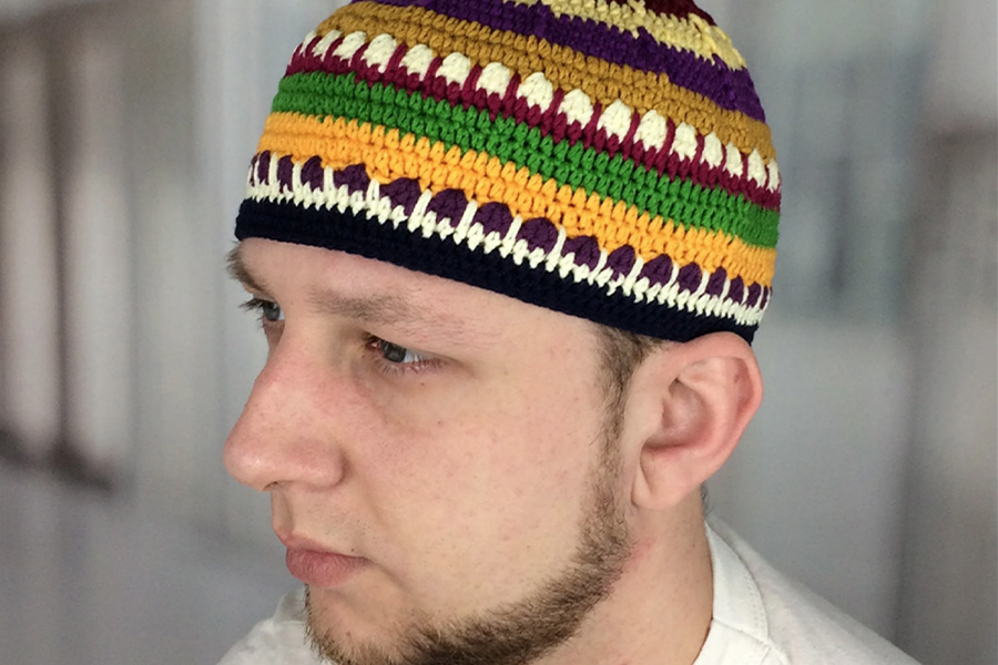 Man wearing a multi-colored skull hat