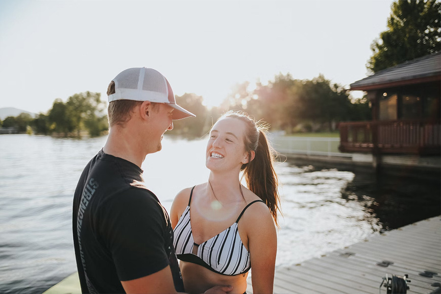 Man with woman wearing a white trucker hat on dock