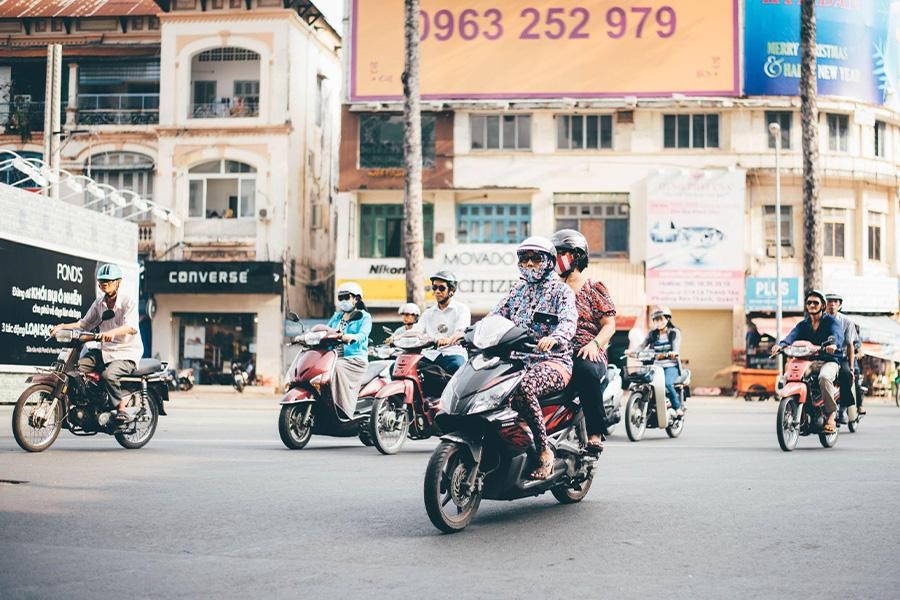 Motorcycle riders on a busy town street.