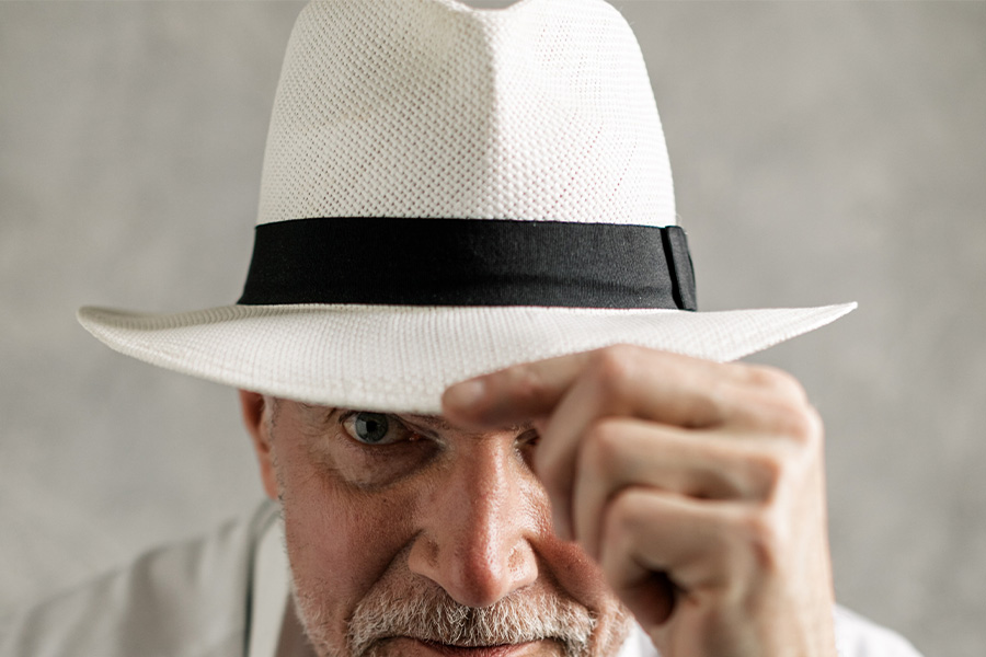 Older man wearing a white and black Fedora hat