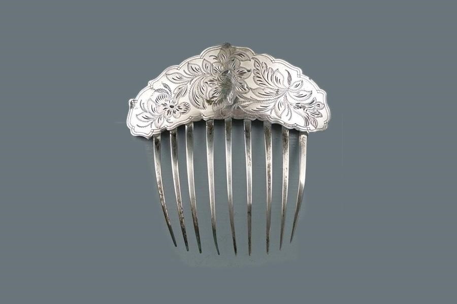 Silver comb pin on a grey background