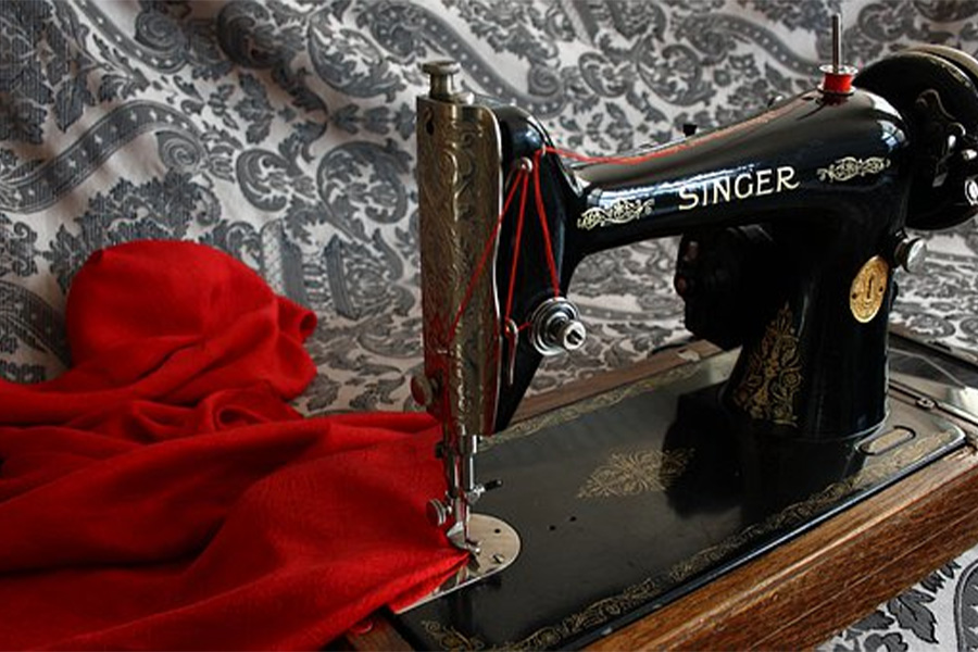 Singer sewing machine sewing red fabric