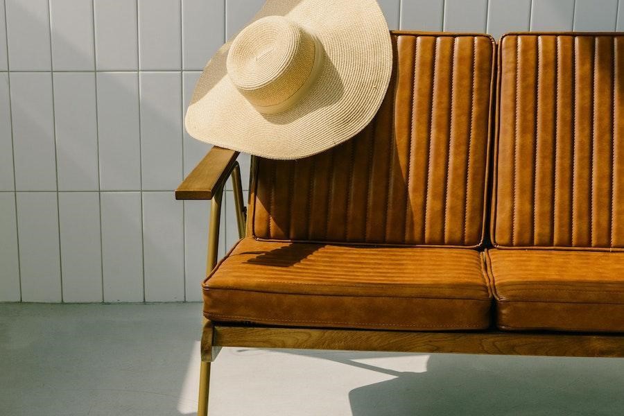 Straw hat hanging on the side of a chair