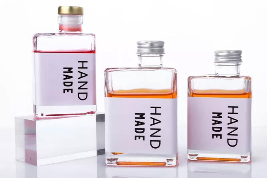 Three glass bottles in square shape with handmade labels