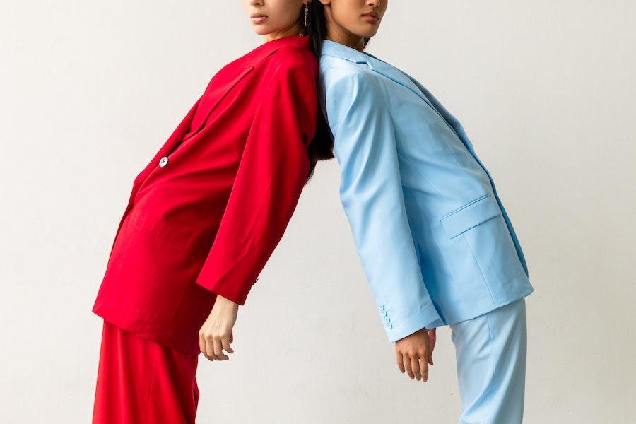 Two women wearing a red and blue 80s suit
