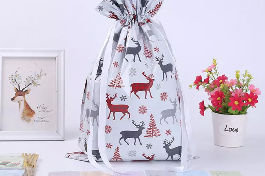 White Christmas gift bag decorated with reindeer and snowflakes