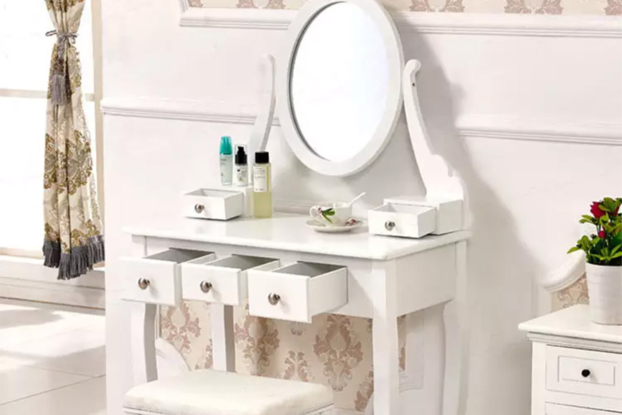 White vintage makeup vanity with an oval mirror