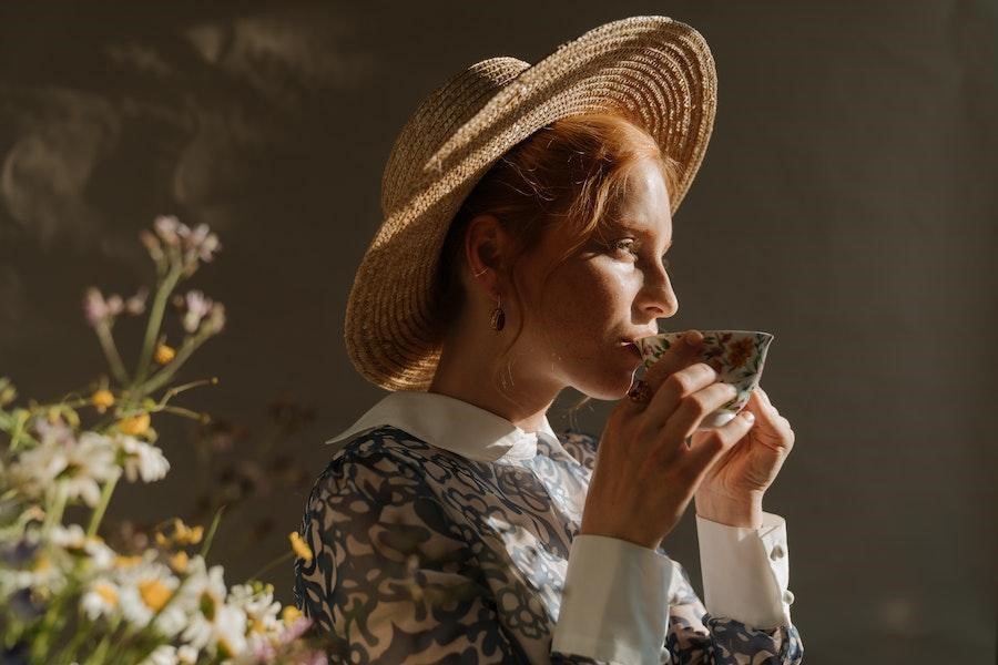 Woman in a straw hat drinking coffee