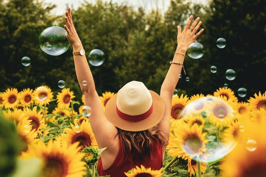 Woman in a sunflower field rocking a straw hat