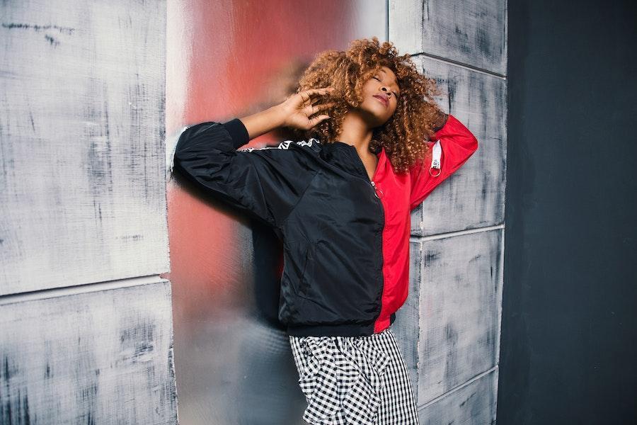 Woman posing with a red and black bomber jacket