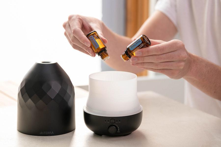 Woman pouring fragrance oil into a nebulizer diffuser